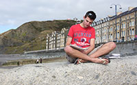 Aberystwyth -University -student -working -on -beach -consti -behind