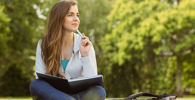 Student sitting thinking in park